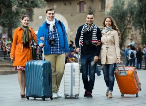 smiling american travelers with baggage sightseeing and smiling in autumn