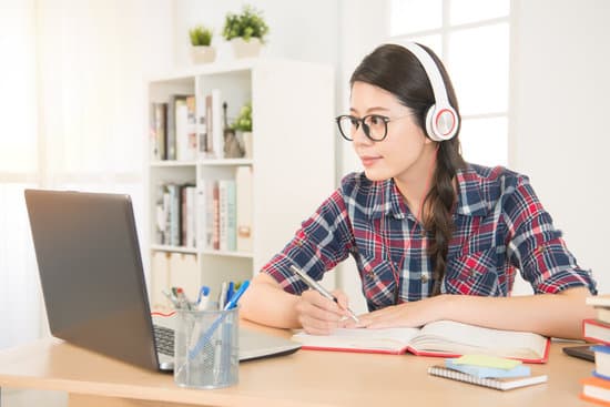 student learning on line with headphones and laptop. mixed race asian chinese model.