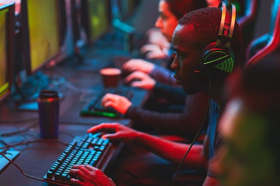 Group of serious focused multi-ethnic gamers sitting in row and playing video game on modern computers