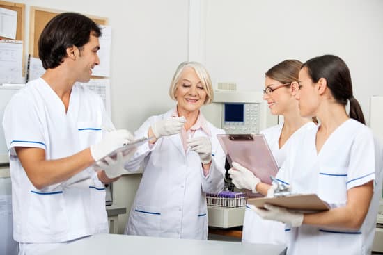 Team of scientists discussing over sample in medical laboratory