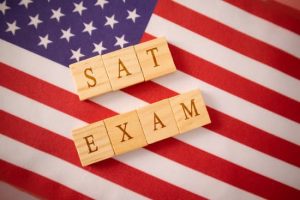 SAT Exam in Wooden block letters on US flag.