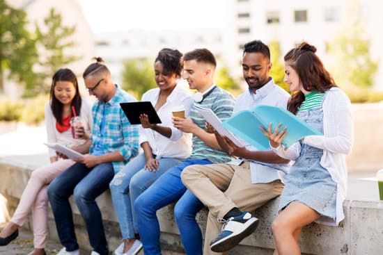 education, international and technology concept - group of happy exchange students with notebooks and tablet pc computer outdoors
