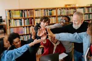 Group of students and professor doing a group high five