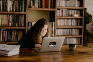 Young woman using her laptop inside their home library