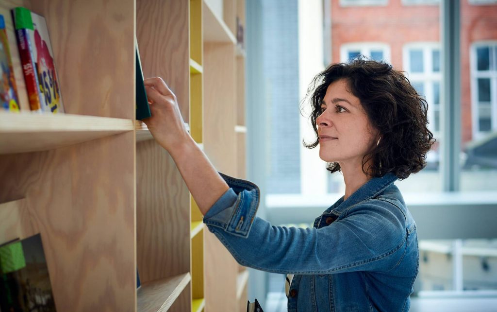 Woman taking a book from a shelf
