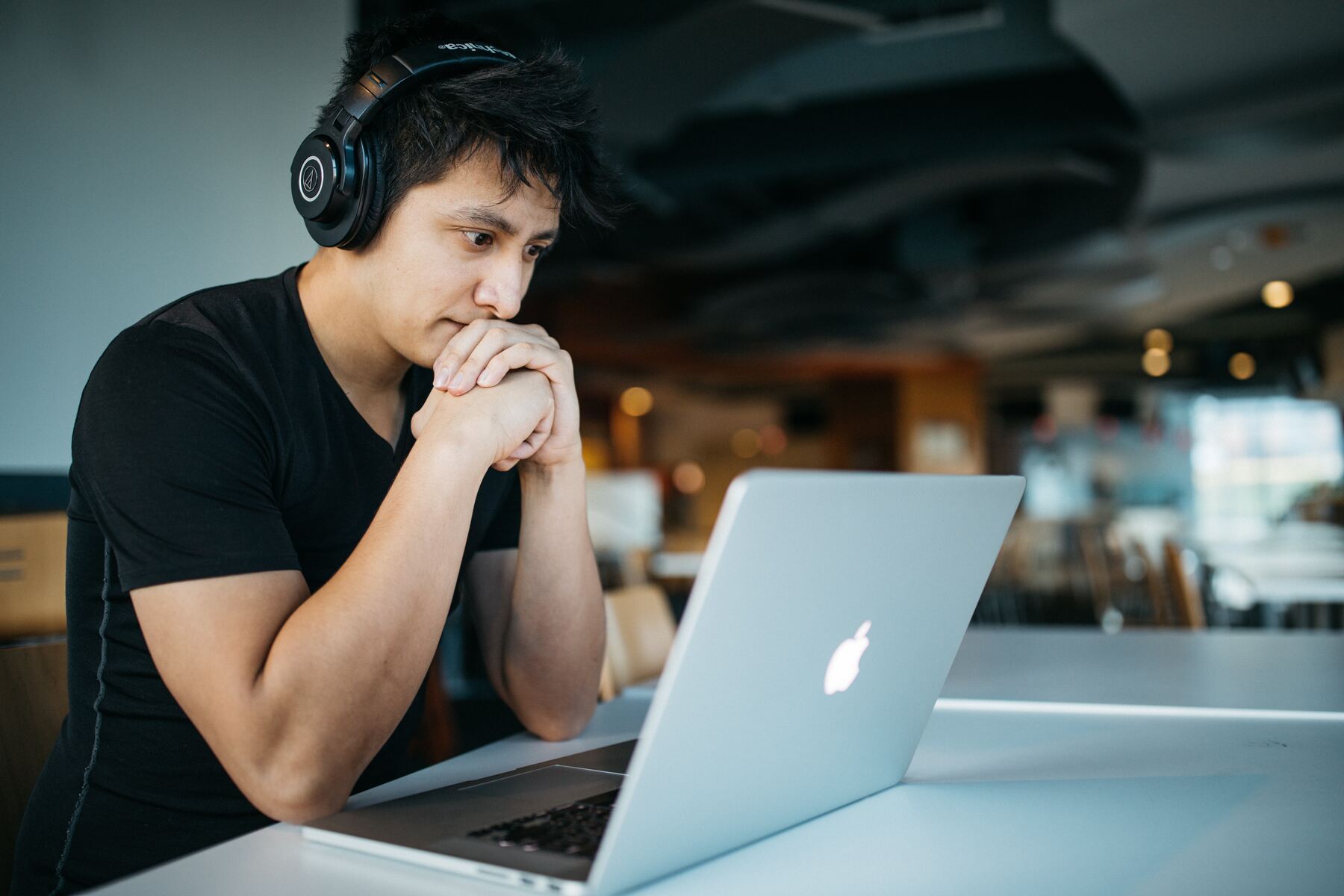 Man wearing headphones while looking at his laptop