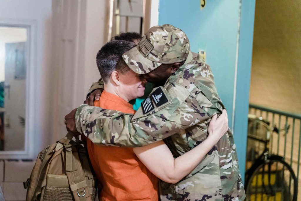 A military hugging his family