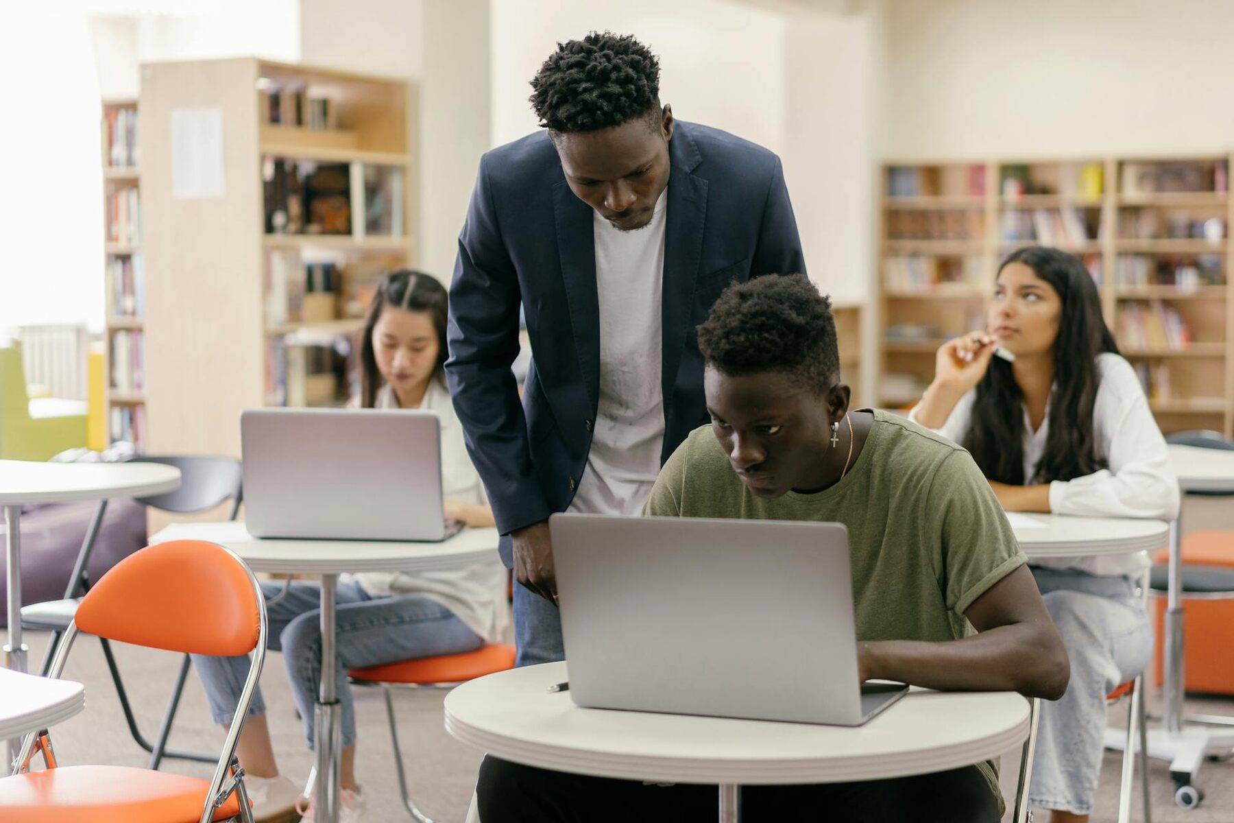 Students with their instructor working on laptops in a library