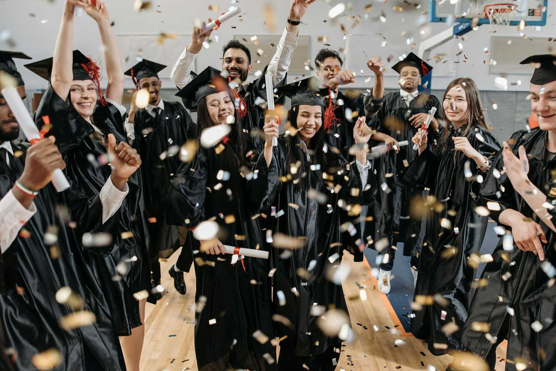 A group of graduates throwing confetti in the air