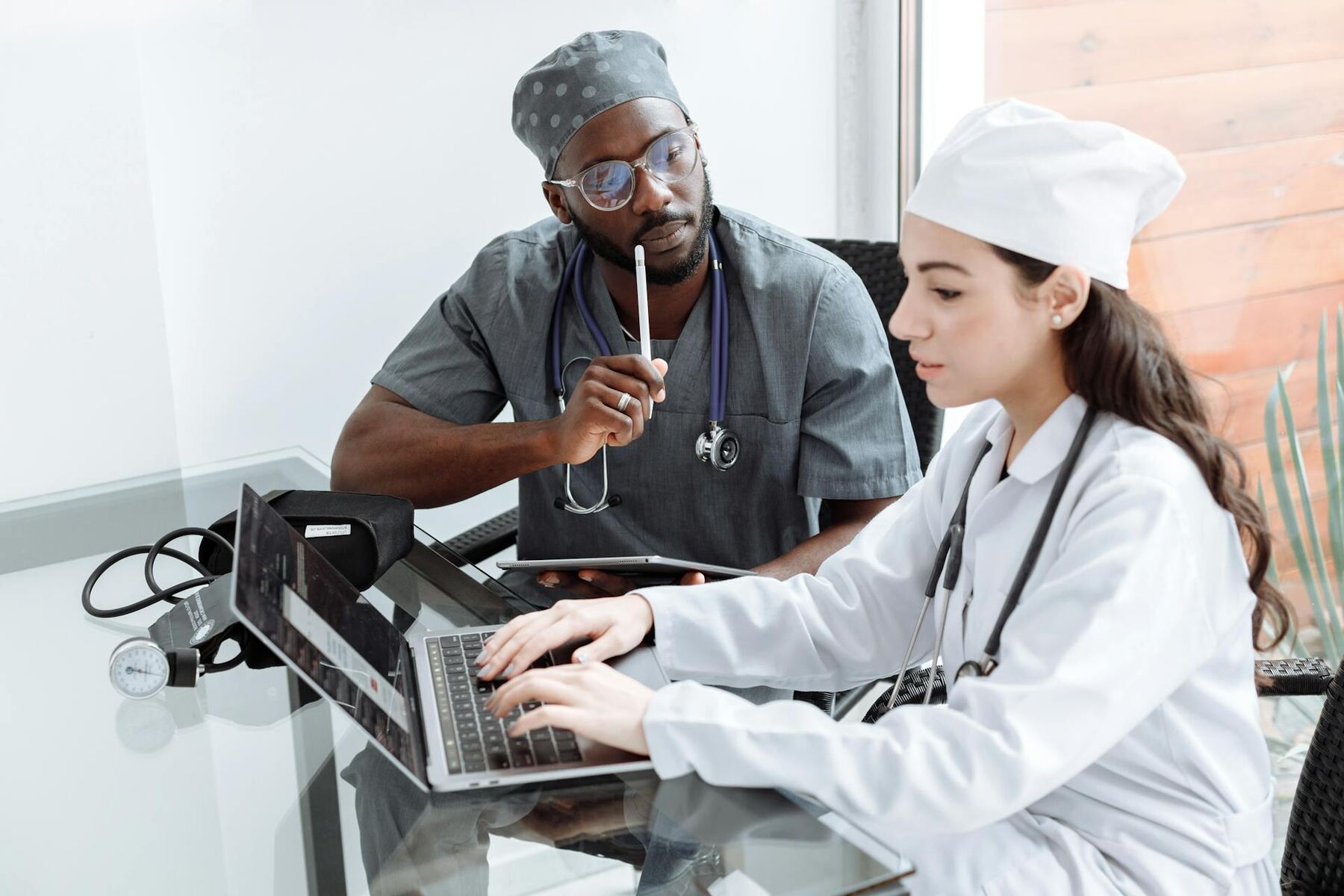 A doctor and nurse collaborating on a laptop to provide efficient medical care