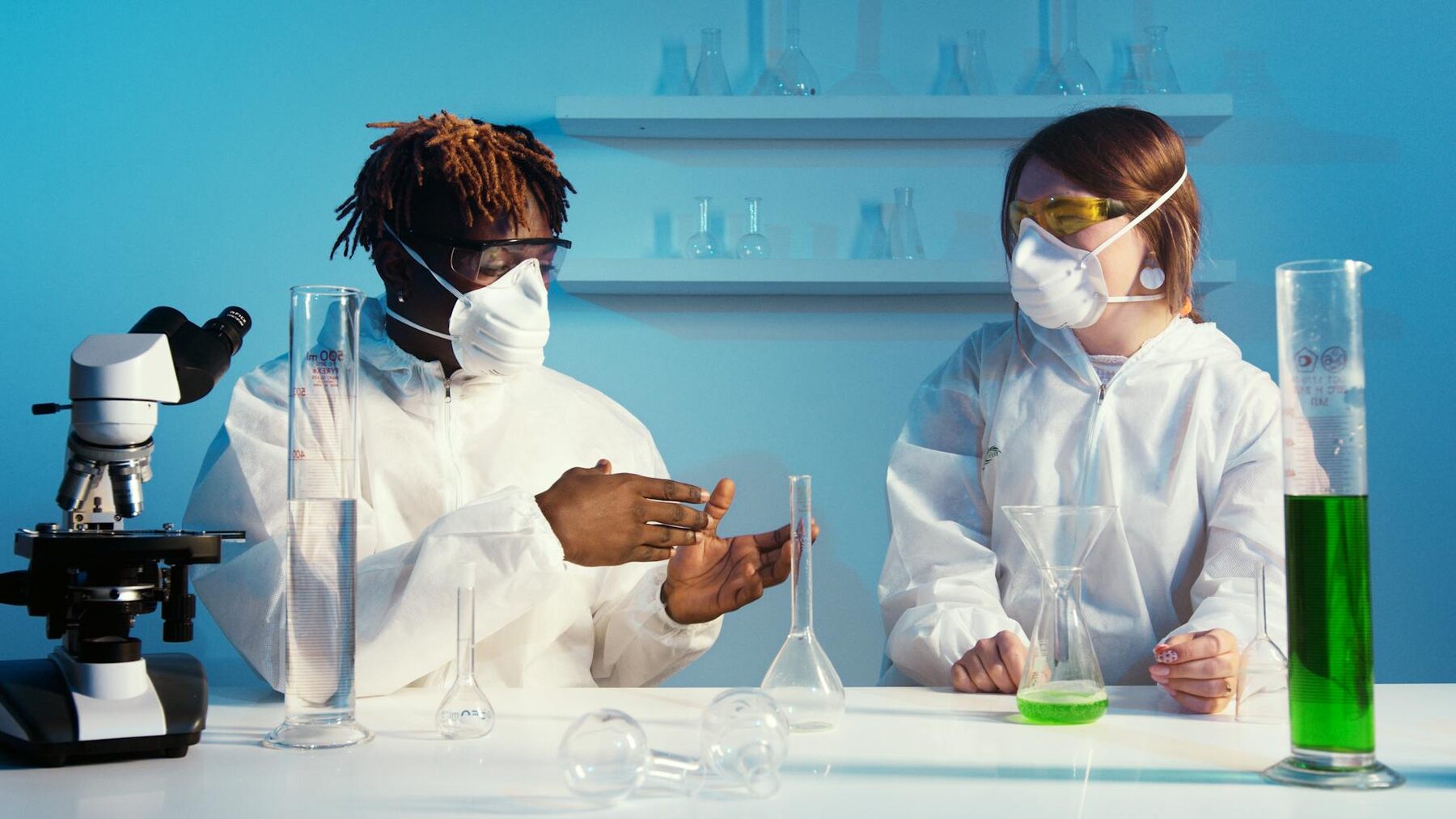 Two researchers in protective gear collaborating on a scientific project